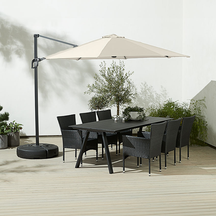 Grande guarda-sol quadrado branco suspenso por cima da mesa de jantar exterior com cadeiras de jardim